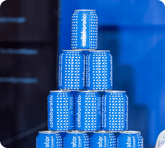 Pyramiden-Stapel blauer Kollaborator-Dosen in mehreren Stufen angeordnet, wodurch ein auffälliges Display vor einem blauen Hintergrund erzeugt wird