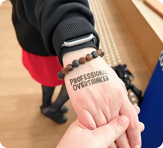 Temporäres „Professional Overthinker“-Tattoo auf der Hand eines Teilnehmers beim Baltic-Nordic SEO Summit 2026.