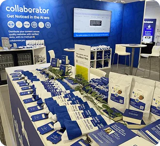 Der Collaborator-Stand auf der BrightonSEO 2026 mit gebrandeten Werbeartikeln, Broschüren und einem Bildschirm mit Präsentation.